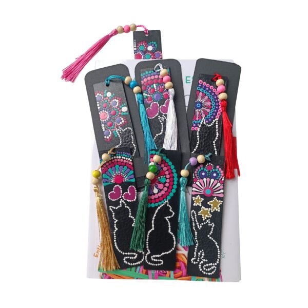 Conjunto de siete separadores de libros artesanales hechos de material negro con diseños coloridos de mandalas, gatos y borlas de hilo de colores. Elaborados en madera con la técnica de puntillismo.