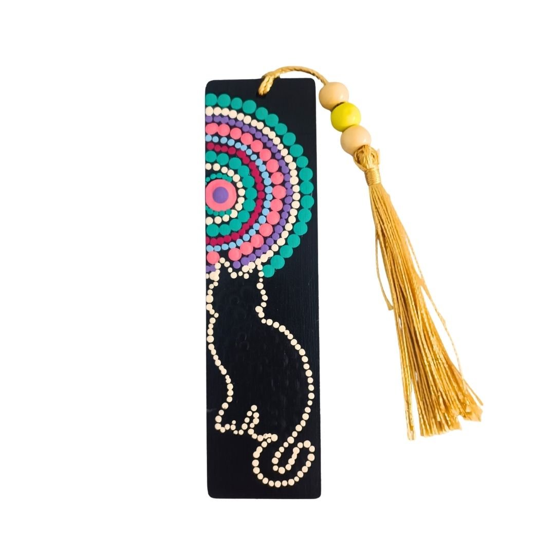 Separador de libros de madera negra con diseño de gato delineado y un mandala incompleto, acompañado de una borla de hilo dorado brillante atada con cuentas.