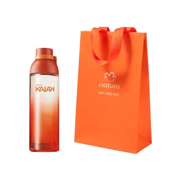 Set de fragancia Natura Kaiak de 100 ml. A la izquierda, un frasco de vidrio con un degradado intenso que va de naranja quemado a transparente en la base, con una tapa circular a tono. A la derecha, una bolsa de papel naranja vibrante con el logotipo de Natura y el eslogan 'bien estar bien'