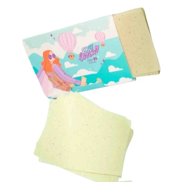 Paquete de papelitos absorbentes de grasa facial "Sky Lover" de Trendy. El empaque es azul claro con ilustraciones de nubes, globos aerostáticos y una chica con gafas. Se muestran varias láminas de papel absorbente de color verde menta con pequeñas motas oscuras saliendo del estuche.