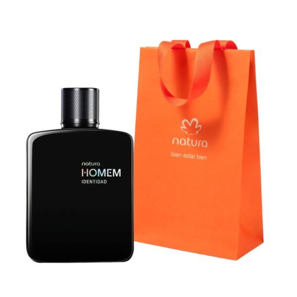 Fotografía de producto sobre fondo blanco. A la izquierda, un frasco de perfume Natura Homem Identidad de cuerpo negro opaco y rectangular con bordes redondeados y tapa cilíndrica negra con textura. A la derecha, una bolsa de regalo de papel color naranja vibrante con asas de cinta del mismo color, que lleva impreso el logotipo de Natura y el eslogan "bien estar bien".